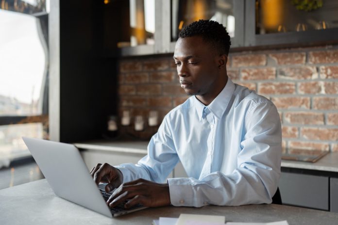 [Illustration] Dans un bureau, un jeune homme face à son ordinateur. @Freepik