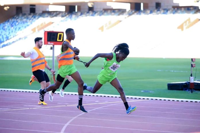 Numédo Akuvi Xana franchit la ligne d'arrivée avec son colistier lors d'une course à Marrakech, avril 2024.