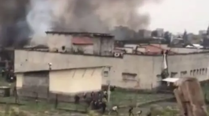 Des images de l’évasion captent des détenus en fuite tandis qu’une épaisse fumée noire s’élève du bâtiment.